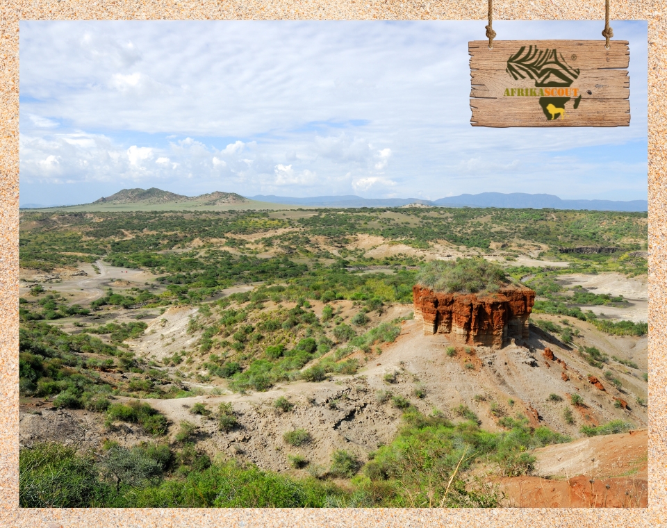 Weitläufige Landschaft der Olduvai-Schlucht in Tansania mit markantem roten Felsplateau – bedeutende archäologische Fundstätte der Menschheitsgeschichte