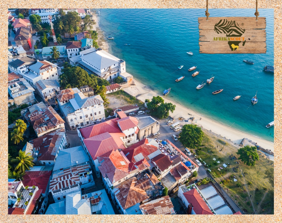 Luftaufnahme von Stone Town auf Sansibar mit roten Dächern, schmalen Gassen und traditionellen Dhau-Booten vor der Küste – historisches Zentrum und UNESCO-Weltkulturerbe in Tansania